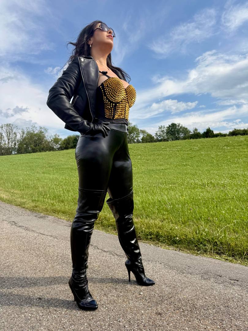 Lederherrin steht selbstbewusst mit Peitsche in der hand dominanz und kraft